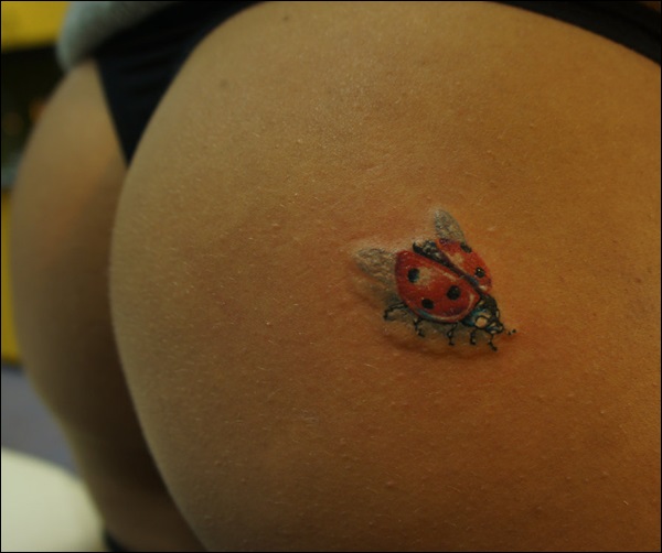 Simple ladybug butt tattoo