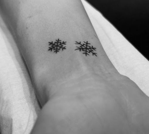 Small black snowflake christmas tattoo