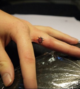 Small ladybug finger tattoo