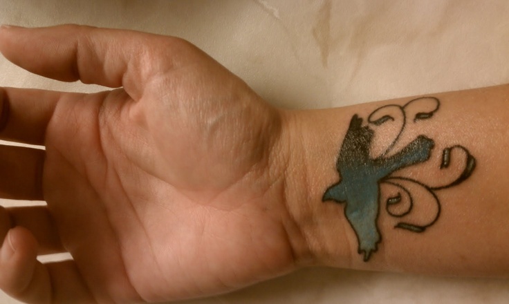 Small mockingbird wrist tattoo