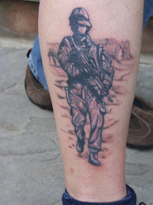Soldier with gun leg tattoo