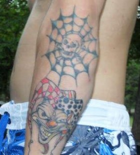 Spider web and clown tattoo