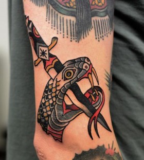 Stabbed snake with a dagger tattoo by Philip Yarnell