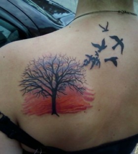 Sunset and tree back tattoo