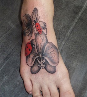 Sweet ladybug and flower foot tattoo