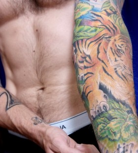 Tiger in jungle arm tattoo