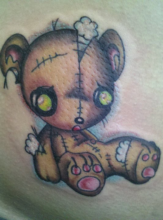 Torn teddy bear tattoo