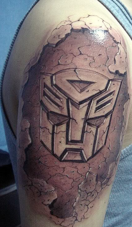 Transformers logo arm tattoo