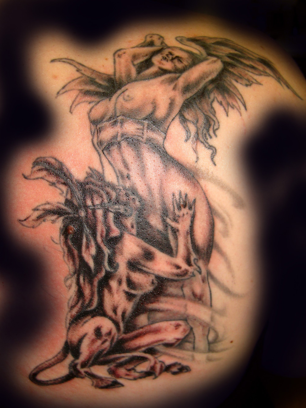 Angel killing demon tattoo meaning
