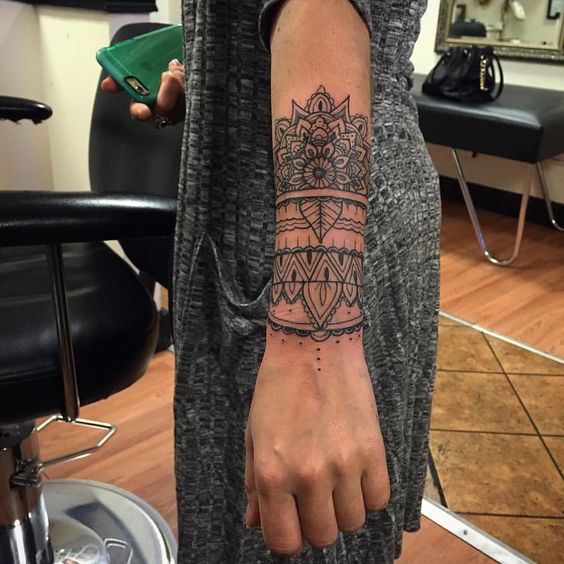 Fine line style half mandala tattoo on the forearm