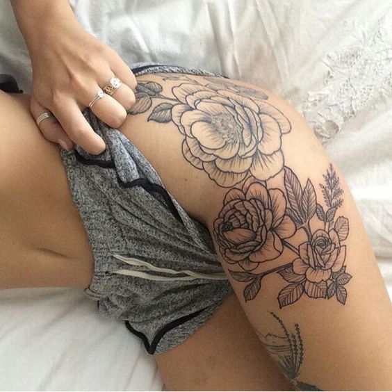 black and grey thigh flower tattoo