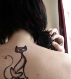 Sleek Black Cat Tattoo on Upper Back