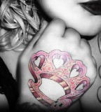 Pink Brass Knuckles With Sugar Skull Tattoo