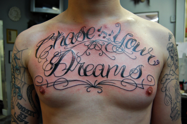 Swirly “Chase Your Dreams” Chest-piece Quote Tattoos for Men