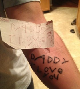 endearing child note on arm man tattoo