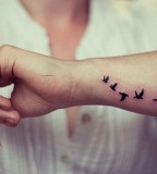 Design Of Flying Bird Silhouette Tattoo On Arm