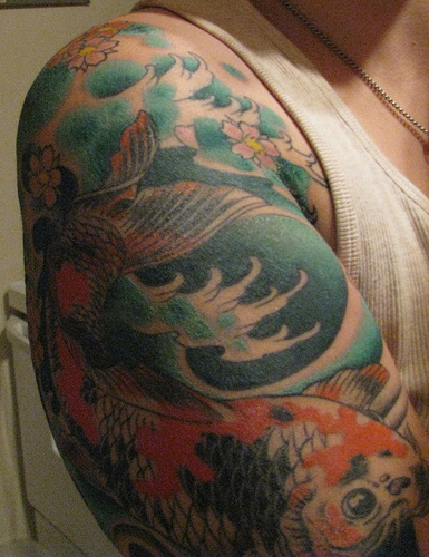 Creative Koi Fish Tattoo Design on Upper Arm for Men