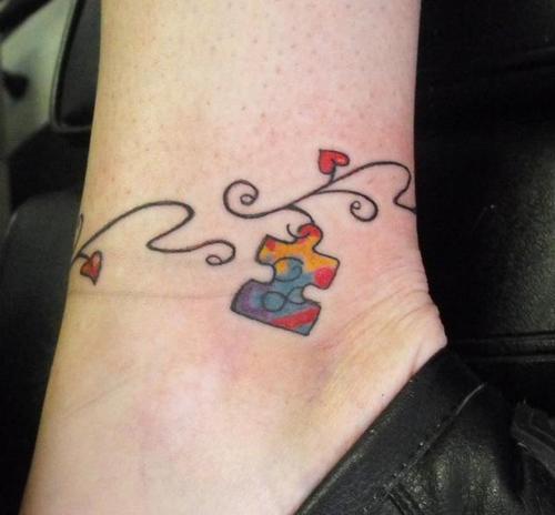 Puzzle Piece Hanging on Swirly Ornament Ankle Tattoo