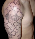 Puzzle Pieces Drawing a City Tattoo on Men Upper Arm