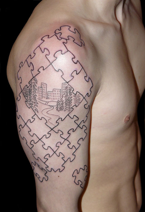 Puzzle Pieces Drawing a City Tattoo on Men Upper Arm