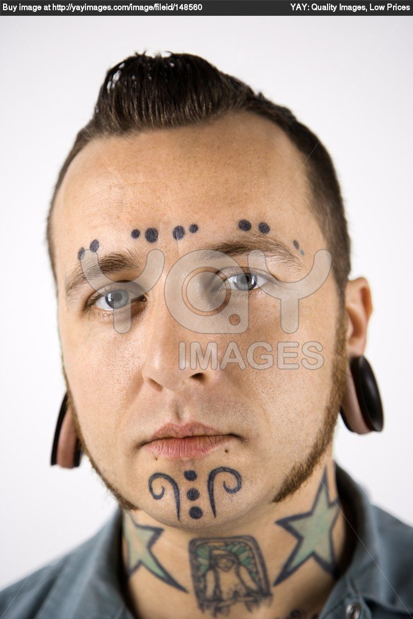 Man With Neck and Face Tattoos And Ear Piercings