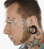 Man With Neck Tattoos And Ear Piercings