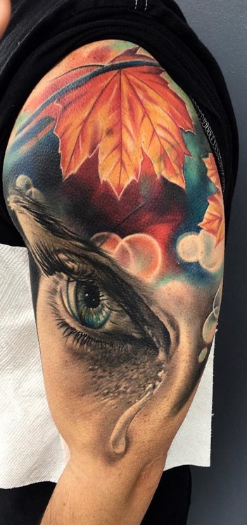 teardrop-on-eye-with-autumn-leaves-background-tattoo
