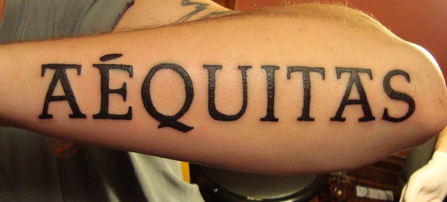 Aequitas Part of Veritas Aequitas Lettering Tattoo on Outer Lower Arm